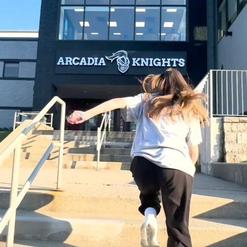 A person running up the steps to the Kuch Gym Building