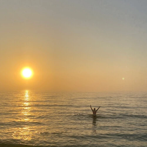 Zara in the ocean during a sunset.