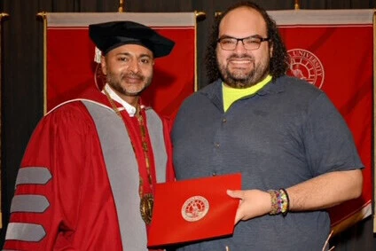 Efrain Nunez '25M receiving his award from President Nair.
