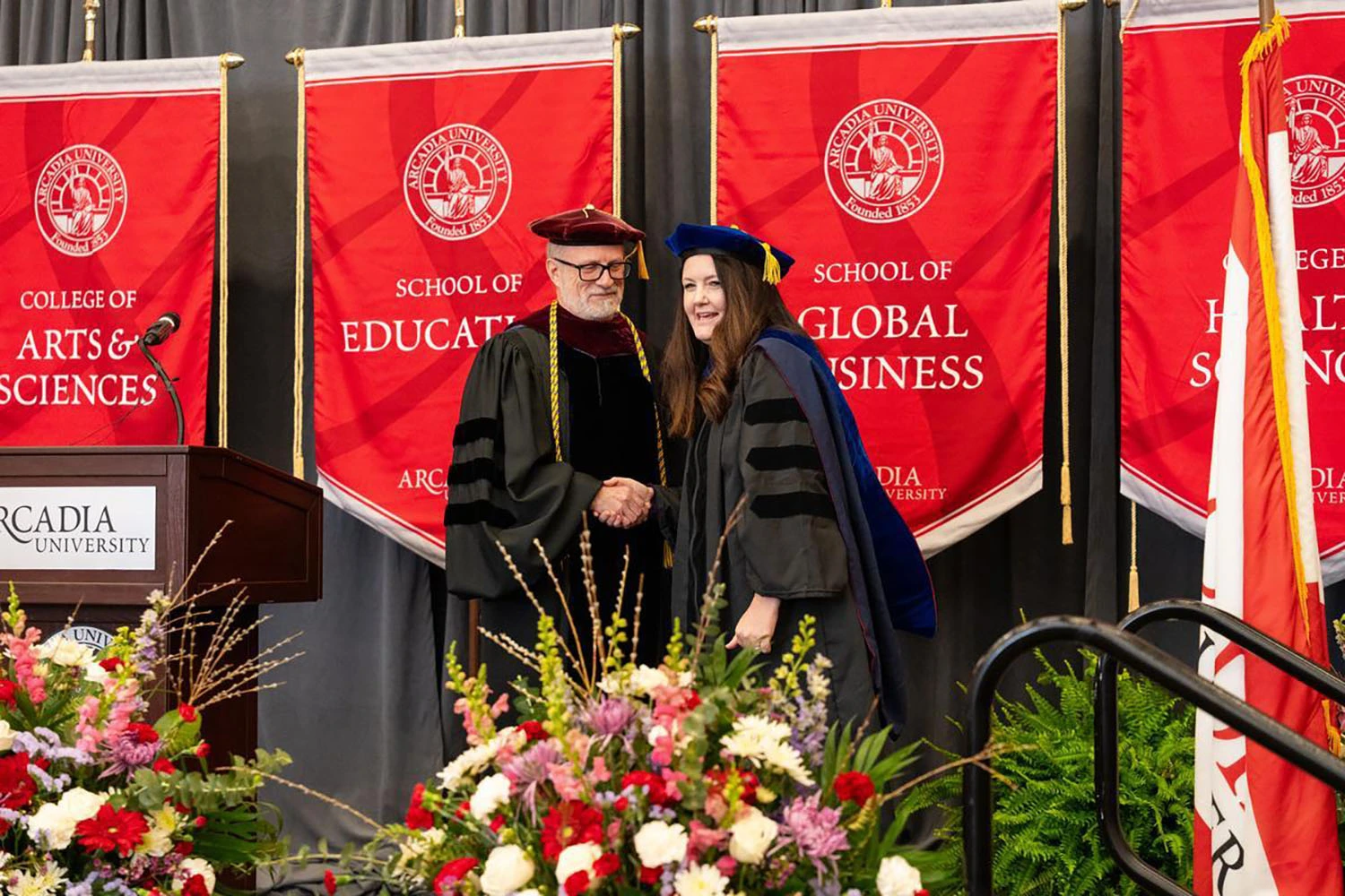 The Provost shaking hands with Dr. McClintock on stage.