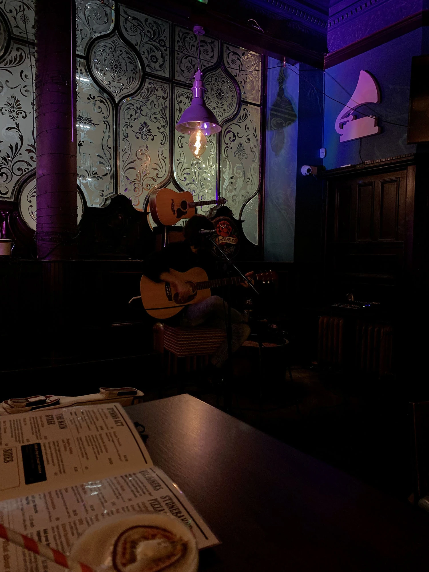 A person playing a guitar in a bar.