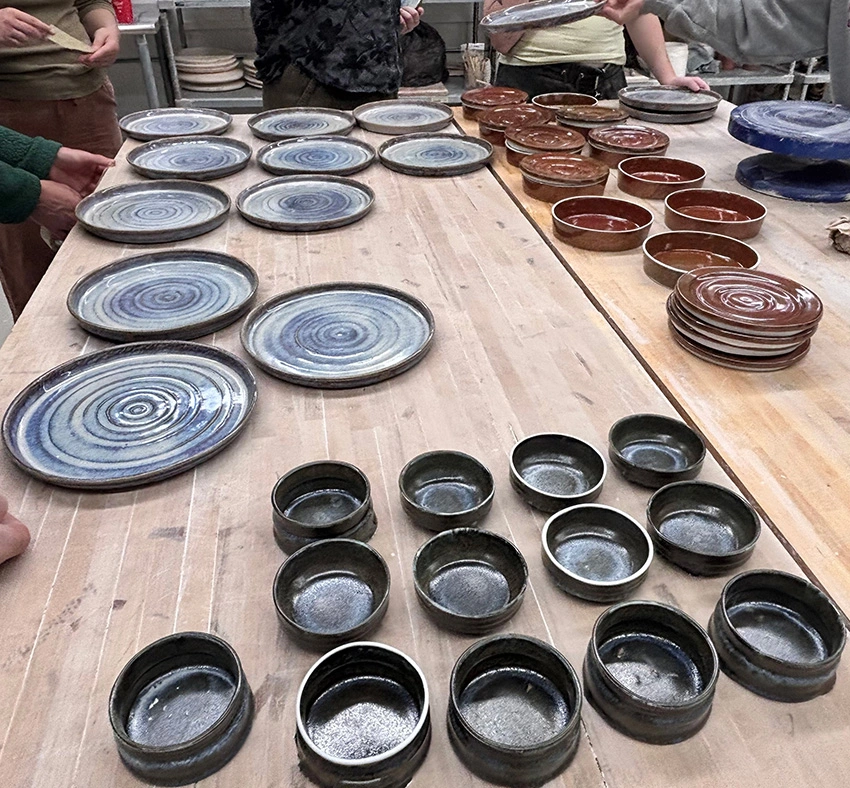 ceramic plates, bowls, and dessert dishes made by Arcadia students