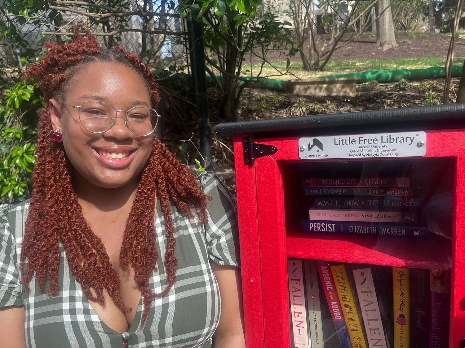 Nakyyia Douglas ’23 ’25M next to one of the little libraries.